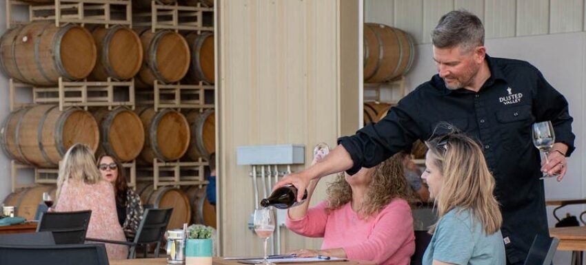 Winemaker, Chad, pouring wine for guests.